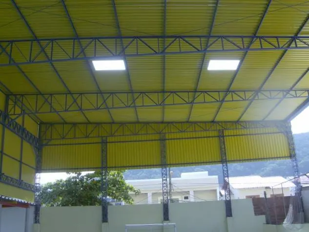 Interior de galpão metálico com cobertura e detalhes em amarelo